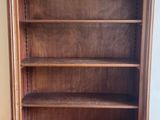 une photo d'une bibliothèque en bois dans un coin d'une pièce