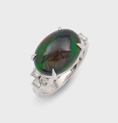 un gros plan d'une bague sertie d'une pierre verte et noire