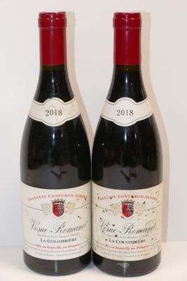 deux bouteilles de vin posées sur une table l'une à côté de l'autre