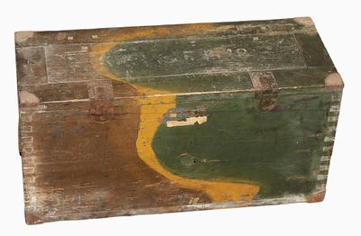 an old wooden trunk with a green and yellow paint on it