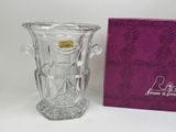a glass vase that is sitting next to a purple box