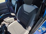 the interior of a small blue van with black seats and a steering wheel