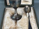 a silver goblet and spoon sitting in a box