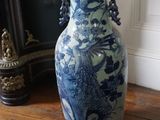 un grand vase bleu et blanc posé sur une table en bois