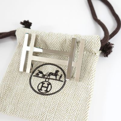 a small bag with a tie bar and a cross on it