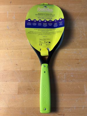 une raquette de tennis posée sur une table en bois, avec un manche vert