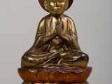 statue d'un Bouddha assis sur une fleur de lotus posée sur une table en bois