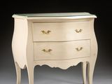 a white chest of drawers with a glass top on a gray surface