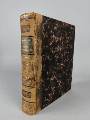 an old book sitting on top of a table next to a white wall