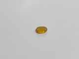 an oval yellow sapphire stone on a white surface