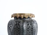 a black and gold vase sitting on a white surface
