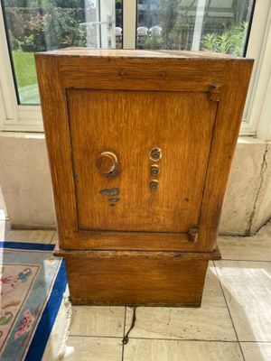 a small wooden cabinet sitting on the floor in front of a window