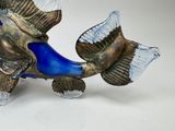 a glass sculpture of a fish on a white surface