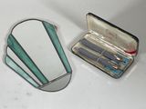 a mirror, scissors, and a case on a table