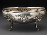 un vieux bol en argent orné de motifs élaborés, posé sur une table