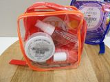 two bags of cosmetics on a table next to a bag of toothpaste