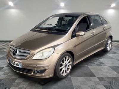 une photo d'une Mercedes Classe B dorée garée sur un sol à damier