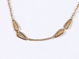 gold plated necklace with a long chain that has a leaf design on it