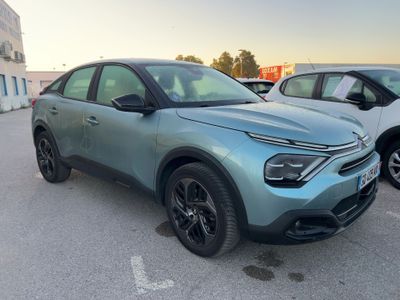 the blue car is parked in the parking lot next to other cars