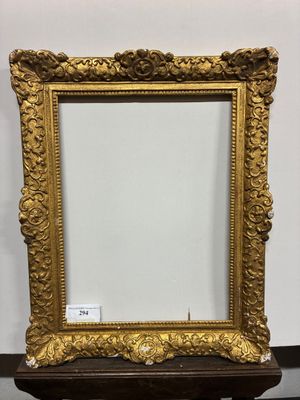 un miroir à cadre doré posé sur un socle en bois, sur fond blanc