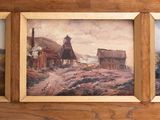 three framed paintings on a wooden wall of a country scene