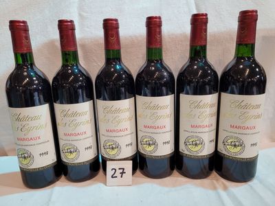 six bouteilles de vin rouge sont alignées sur une table