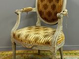 an old chair with a gold velvet upholstered seat