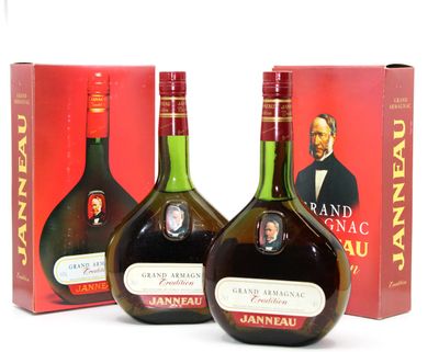 deux bouteilles de brandy et une boîte de vin posées sur une surface blanche