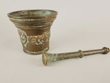a small metal cup and a wooden handle on a white surface