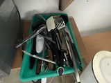 a green container full of kitchen utensils on a table
