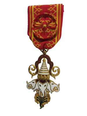 une image représentant une médaille rouge et dorée sur laquelle figure un éléphant blanc