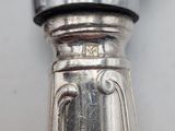 a close up of a silver spoon on a white surface