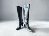 pair of black leather boots on a white floor