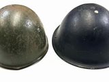 two helmets sitting side by side next to each other on a white surface