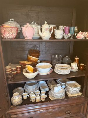 a china cabinet with a lot of dishes and cups on it