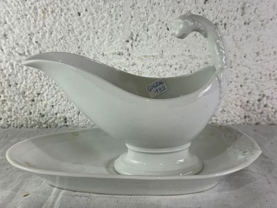 a gravy dish on a saucer on a plate