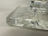 a glass candle holder with a candle on top of it