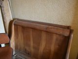 a wooden sleigh bed with a wooden headboard