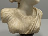 marble bust of a woman wearing a hat and a dress