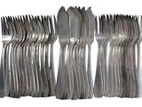 a lot of forks and spoons stacked on top of each other