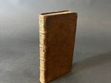 an old book sitting on top of a table next to a gray background