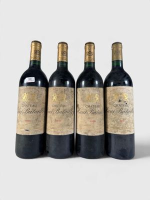 trois bouteilles de vin rouge sont alignées sur une surface blanche