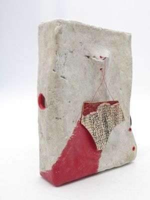 sculpture représentant un objet rouge et blanc sur une surface blanche