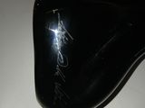 a close up of a black shoe with a signature on it