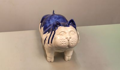 un cochon en céramique avec des cheveux bleus sur la tête