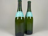 two bottles of wine sitting on top of a table next to each other