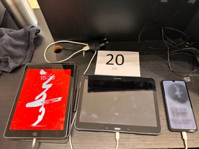 several electronic devices are sitting on a table next to a phone