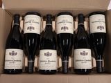 six bouteilles de vin dans un carton sur une table