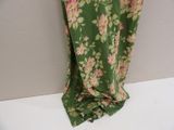 a green and pink floral dress hanging on a wall