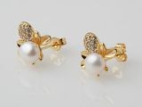 a pair of earrings with pearls and diamonds on a white background